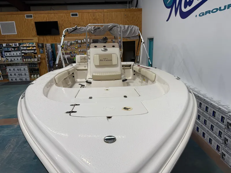Slide: The Image of 2019 Carolina Skiff 19 Sea Chaser boat displayed indoors, showcasing spacious deck and seating. - 8