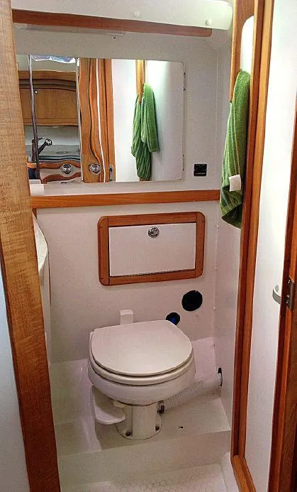 Slide: The Image of 2004 Catalina 42 MkII yacht bathroom with toilet, mirror, and wooden accents. - 13