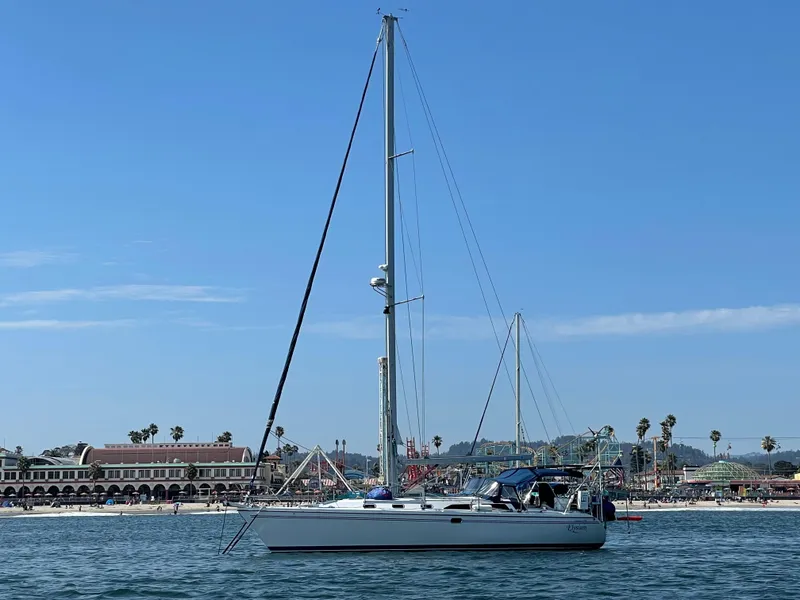 Slide: The Image of 2004 Catalina 42 MkII sailboat on calm water near a coastal town. - 19