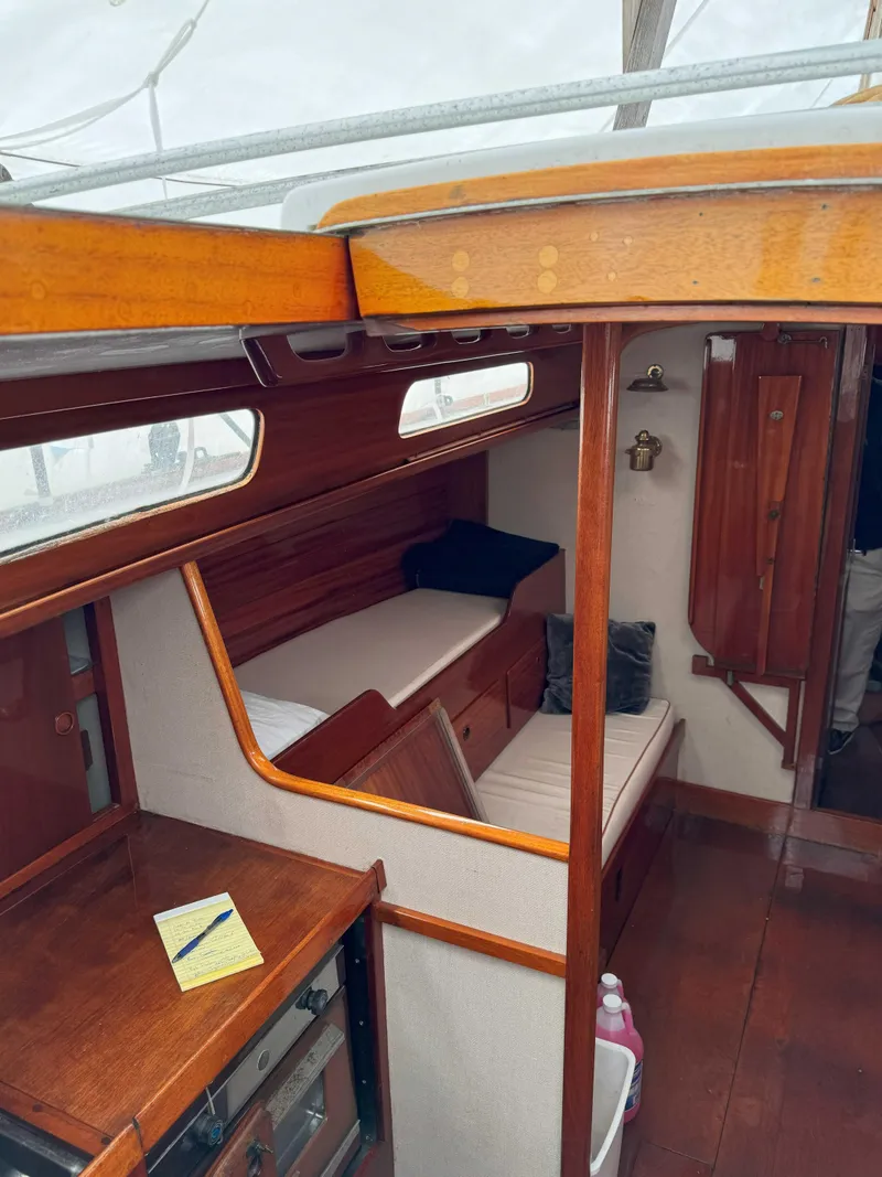 Slide: The Image of Interior of a 1969 Ohlson 38 sailboat, featuring wooden finishes and cozy seating. - 13