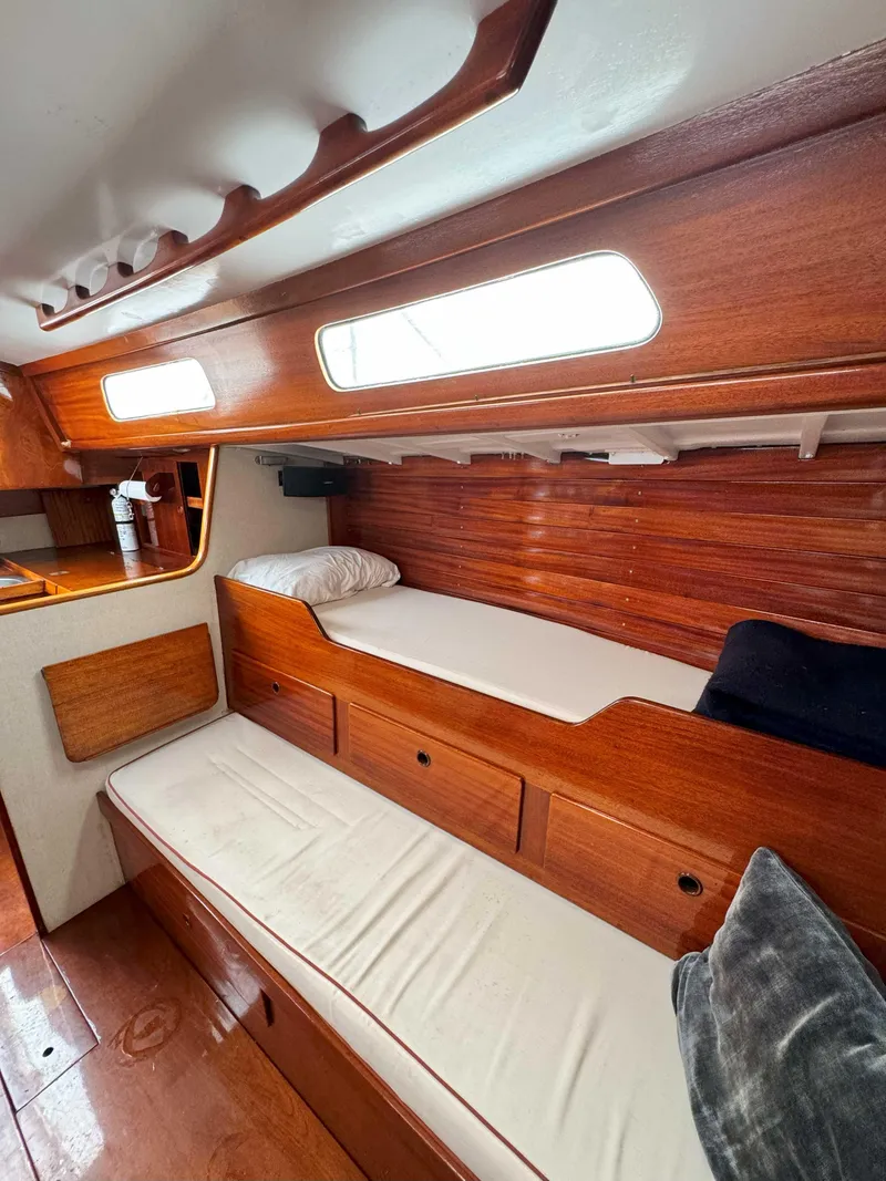 Slide: The Image of Interior of a 1969 Ohlson 38 sailboat with wooden paneling and cushioned seating. - 16