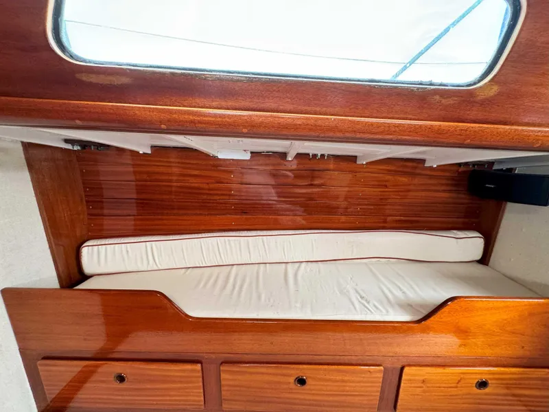 Slide: The Image of Interior cabin of a 1969 Ohlson 38 sailboat with wooden finish and cushioned seating. - 18