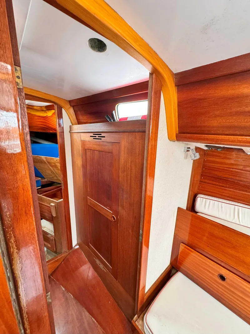 Slide: The Image of Interior of a 1969 Ohlson 38 sailboat, featuring wooden cabinetry and cozy seating. - 19