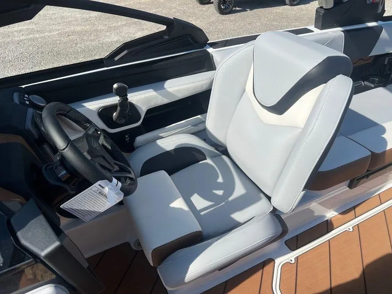 Slide: The Image of 2025 Malibu 23 LSV boat interior with sleek, modern seating and steering wheel. - 7