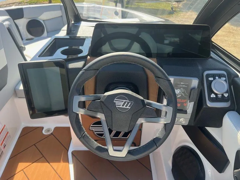 Slide: The Image of 2025 Malibu 23 LSV boat dashboard with modern steering and digital displays. - 8