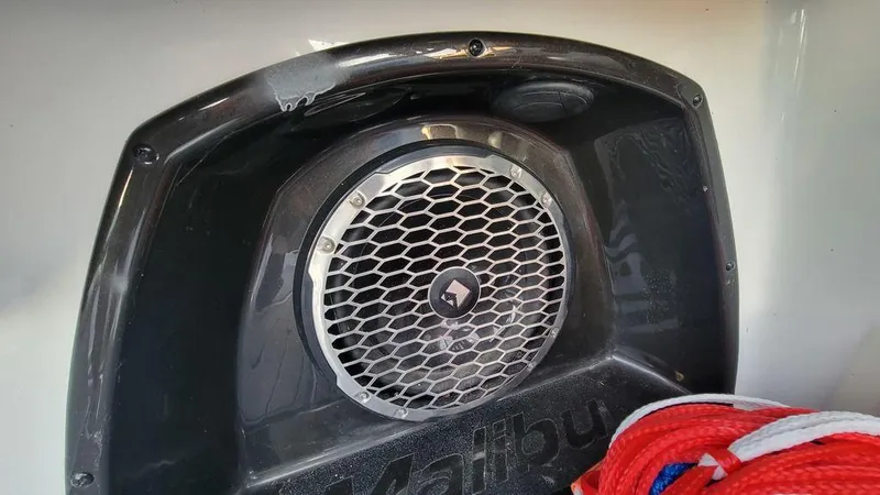 Slide: The Image of Speaker system on a 2015 Malibu 24 MXZ boat with red and blue rope nearby. - 12
