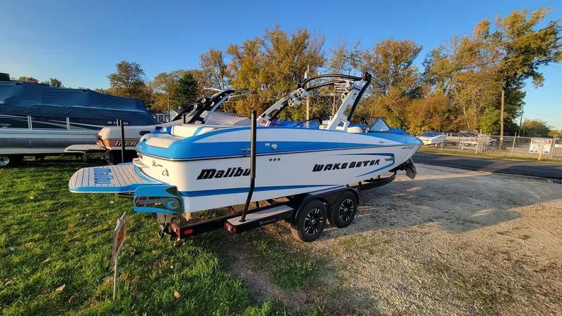Slide: The Image of 2015 Malibu 24 MXZ Wakesetter boat on trailer, parked outdoors. - 21