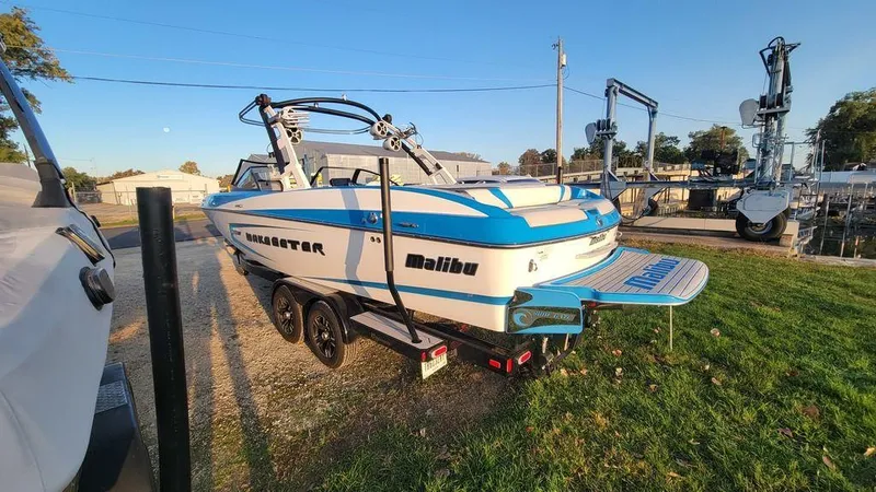 Slide: The Image of 2015 Malibu 24 MXZ boat with blue and white design on a trailer. - 22