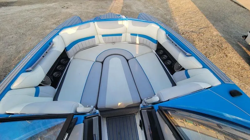 Slide: The Image of 2015 Malibu 24 MXZ boat interior with blue and white seating. - 4