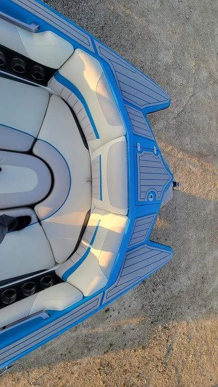 Slide: The Image of 2015 Malibu 24 MXZ boat interior with blue and white seating, viewed from above. - 5
