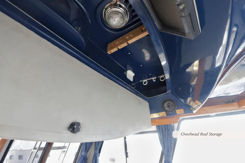Slide: The Image of 1988 Mediterranean 38 Convertible boat with overhead rod storage and blue interior ceiling. - 16