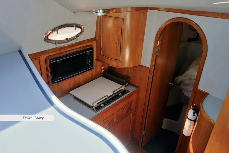 Slide: The Image of 1988 Mediterranean 38 Convertible yacht galley with wood cabinetry and modern appliances. - 17