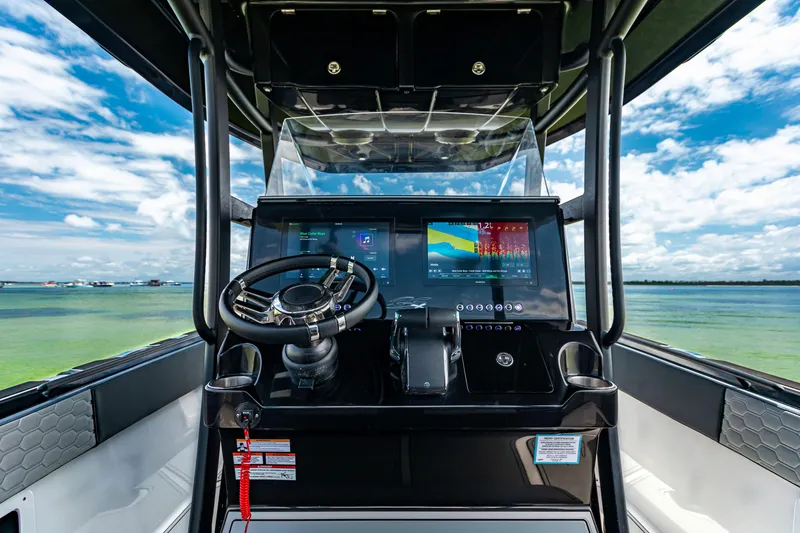 Slide: The Image of 2025 Glasstream GSX boat dashboard with steering wheel and digital displays, set against a scenic water view. - 13