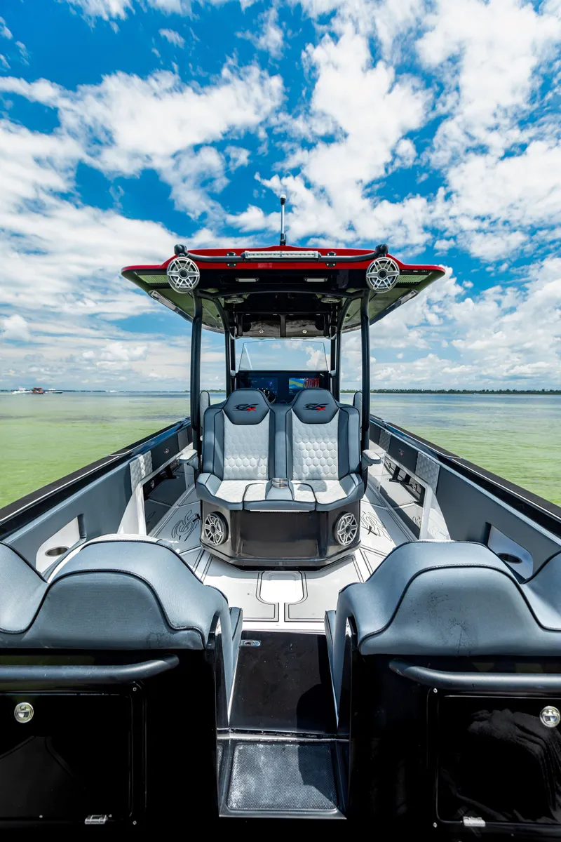 Slide: The Image of 2025 Glasstream GSX boat interior with modern seating, under a vibrant blue sky. - 16