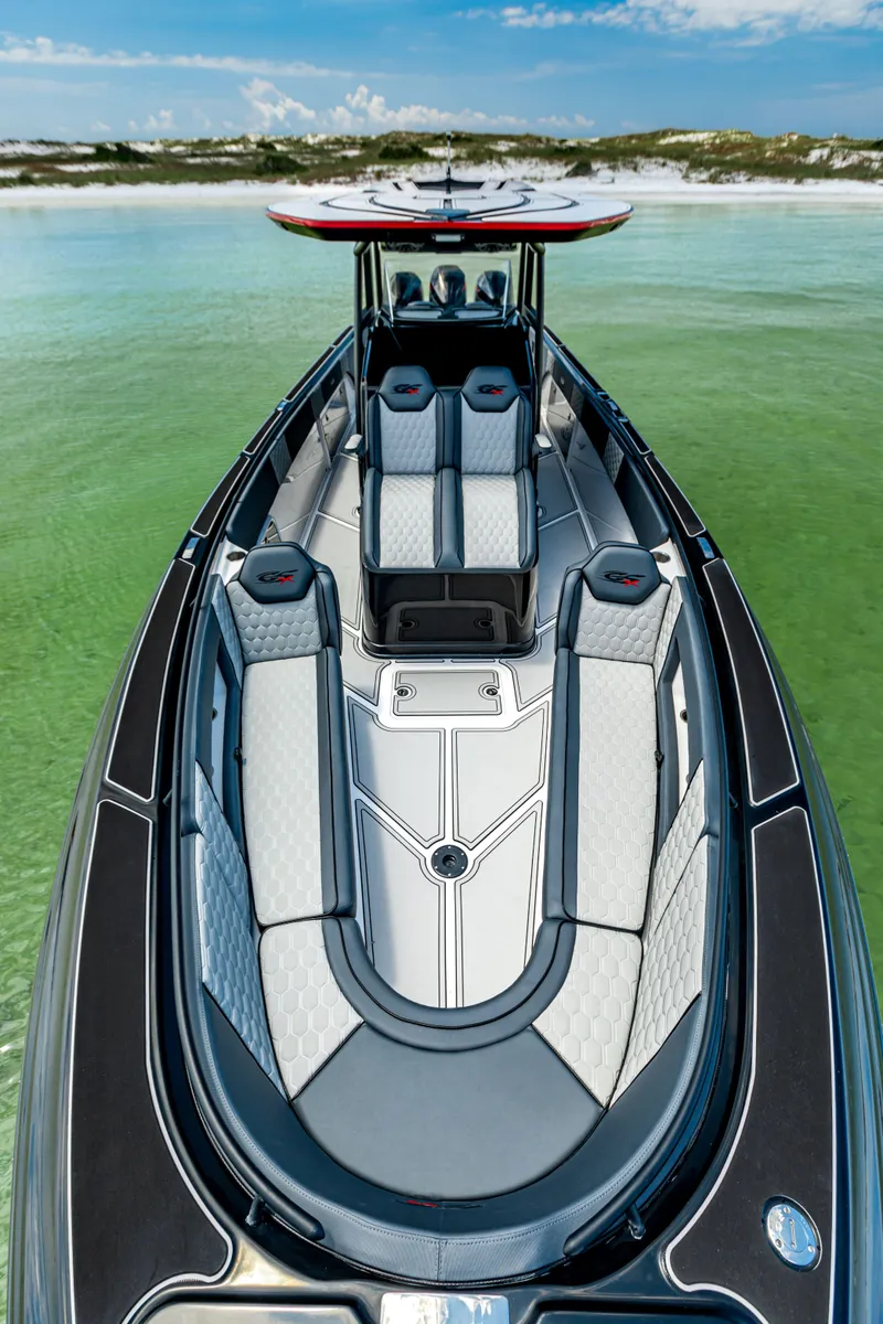 Slide: The Image of 2025 Glasstream GSX boat on calm green water, featuring sleek design and modern seating. - 19