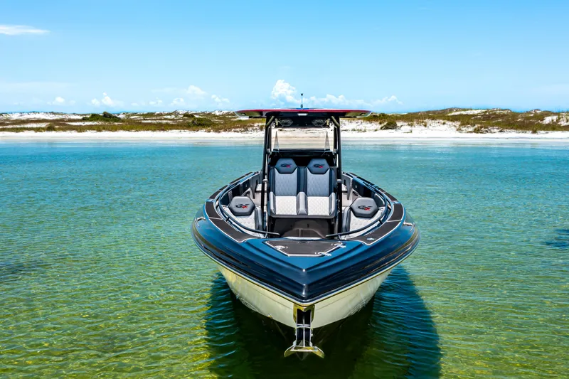 Slide: The Image of 2025 Glasstream GSX boat in clear turquoise water, sandy shoreline in background. - 2