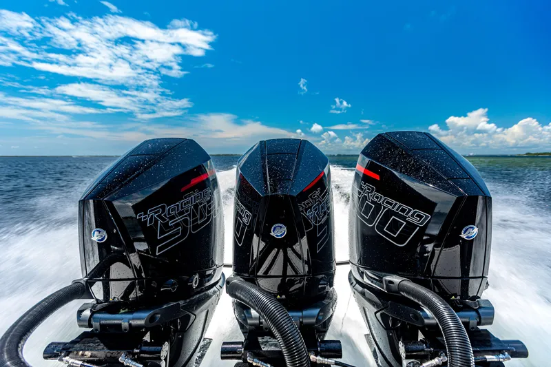 Slide: The Image of Triple outboard engines on a 2025 Glasstream GSX boat, speeding across the water. - 22