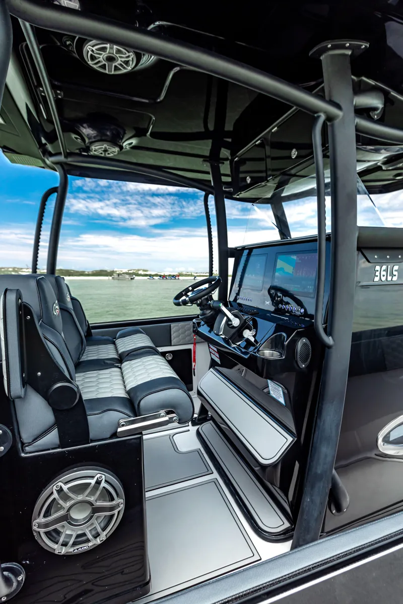 Slide: The Image of 2025 Glasstream GSX boat interior with modern dashboard and seating, overlooking serene water. - 5