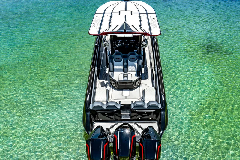 Slide: The Image of 2025 Glasstream GSX boat on clear turquoise water, featuring sleek design and triple engines. - 9