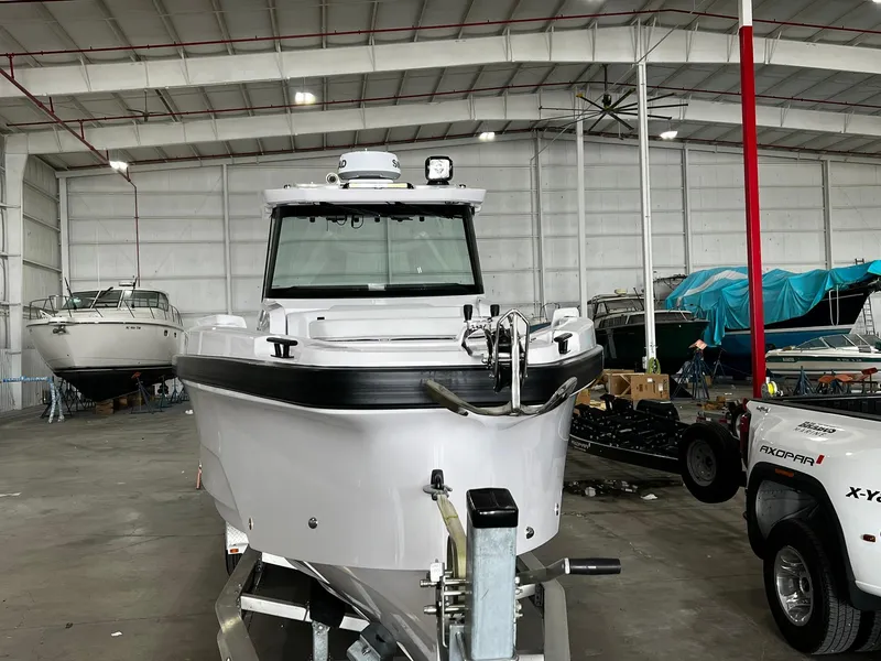 Slide: The Image of 2025 Axopar 29 CCX boat on trailer in indoor showroom. - 2