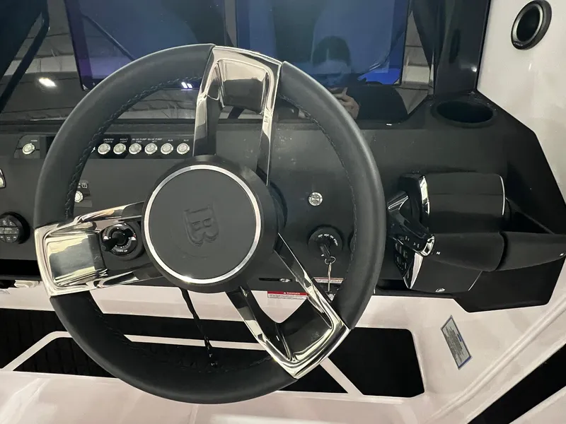 Slide: The Image of 2025 Axopar 29 CCX boat interior with seating and table, displayed outdoors. - 20