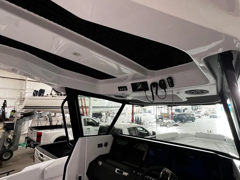 Slide: The Image of 2025 Axopar 29 CCX boat, sleek white design, modern features, docked on a sunny day. - 26