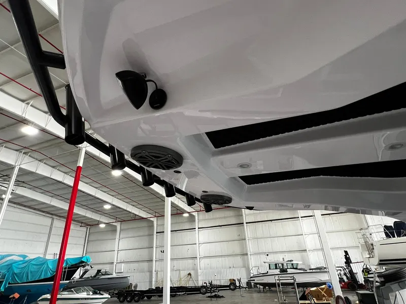 Slide: The Image of 2025 Axopar 29 CCX boat with open storage compartment, parked outdoors. - 27