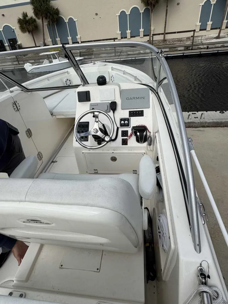 Slide: The Image of 2023 Cobia 220 DC boat interior with steering wheel and Garmin navigation system. - 3
