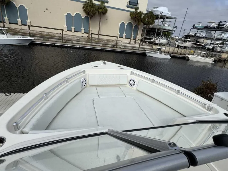 Slide: The Image of 2023 Cobia 220 DC boat docked, showcasing spacious bow seating and sleek design. - 7