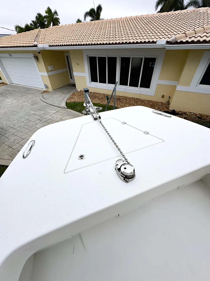 Slide: The Image of 2013 Twin Vee 26 Center Console boat parked in front of a house. - 13