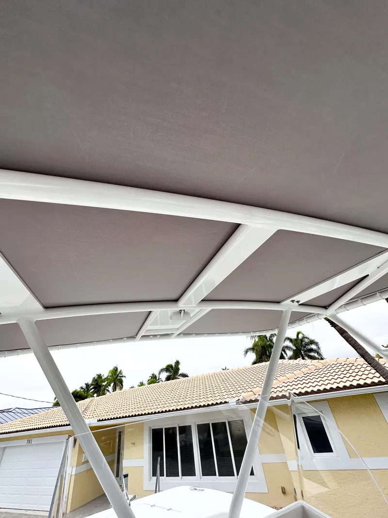 Slide: The Image of 2013 Twin Vee 26 Center Console boat canopy with house background. - 16