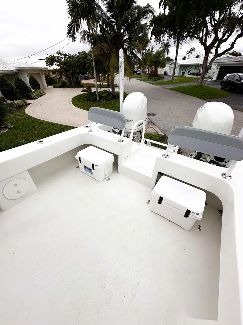 Slide: The Image of 2013 Twin Vee 26 Center Console boat with dual engines, parked in a residential area. - 22