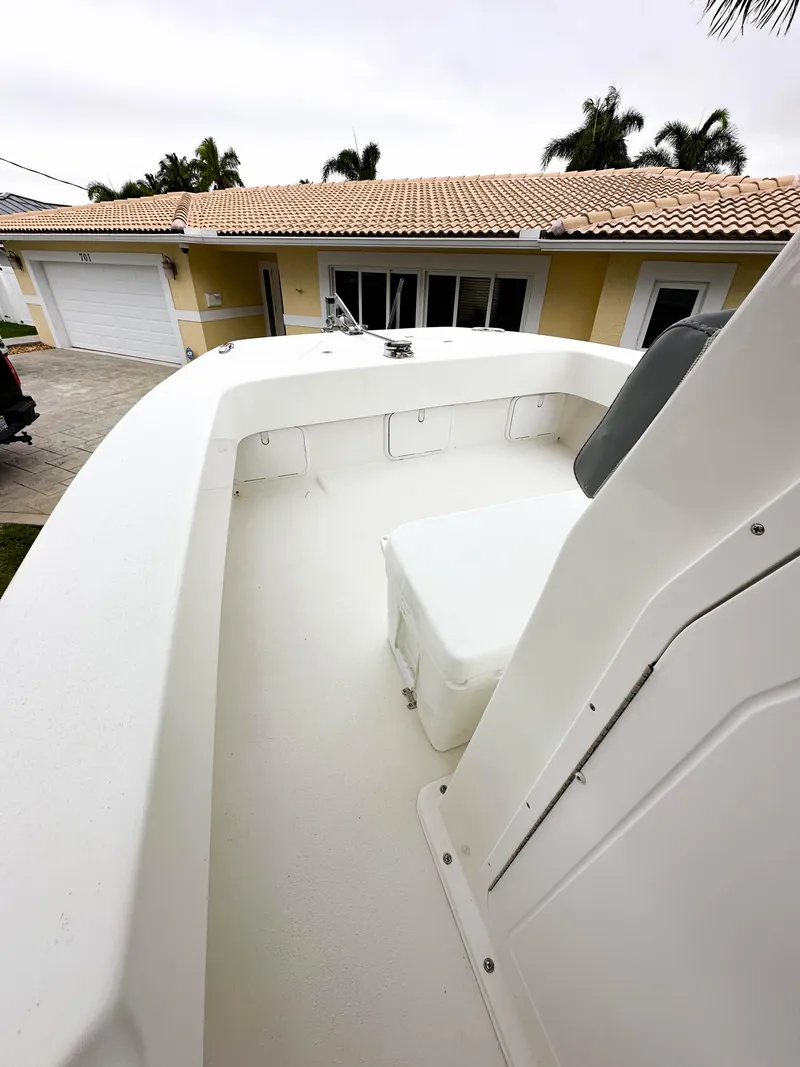 Slide: The Image of 2013 Twin Vee 26 Center Console boat parked near a house. - 24