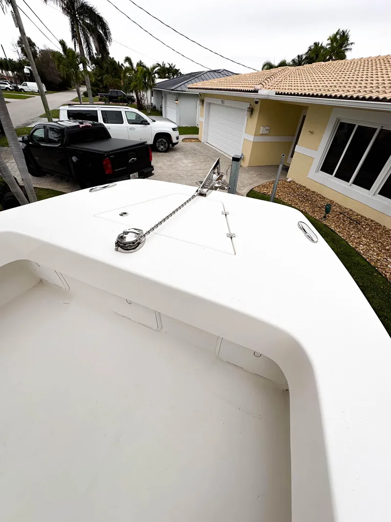 Slide: The Image of 2013 Twin Vee 26 Center Console boat parked in a residential driveway. - 26