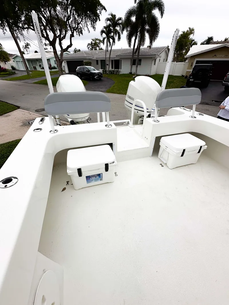 Slide: The Image of 2013 Twin Vee 26 Center Console boat with seating and storage, parked in a residential area. - 28