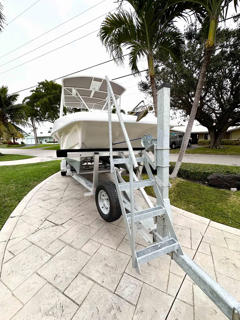 Slide: The Image of 2013 Twin Vee 26 Center Console boat on trailer, surrounded by palm trees. - 3