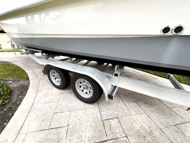 Slide: The Image of 2013 Twin Vee 26 Center Console boat on a dual-axle trailer. - 30