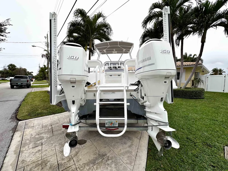 Slide: The Image of 2013 Twin Vee 26 Center Console boat with dual Yamaha 150 engines, parked on a driveway. - 7