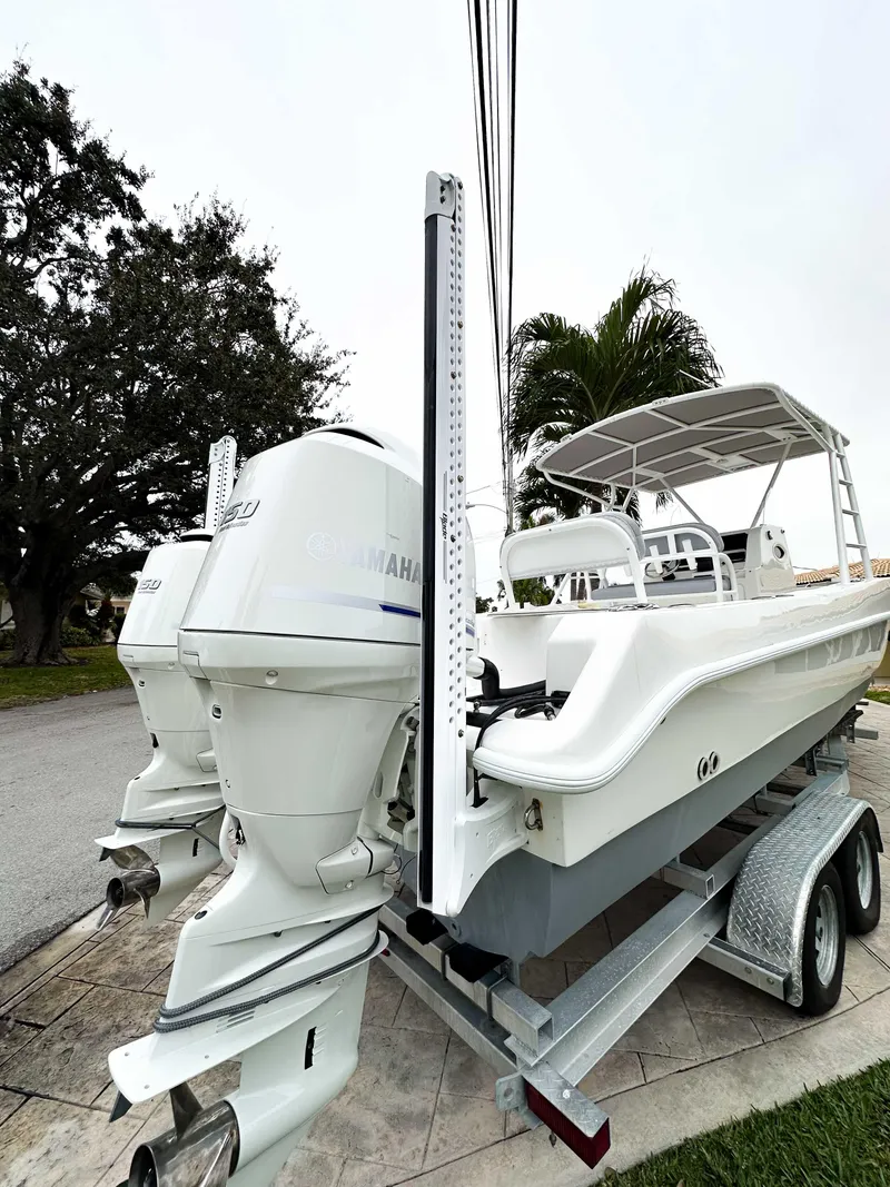 Slide: The Image of 2013 Twin Vee 26 Center Console boat on trailer with dual outboard engines. - 8