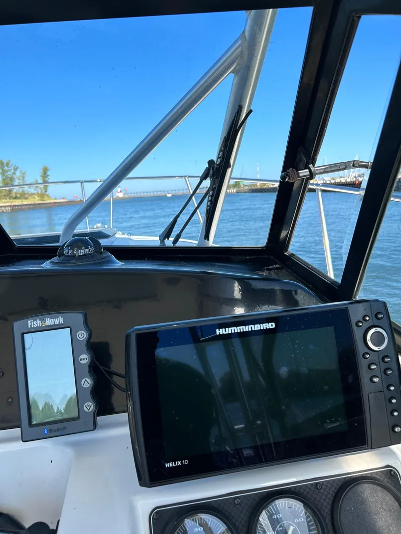 Slide: The Image of 1996 Trophy 2352 Walkaround boat dashboard with Humminbird navigation system on a sunny day. - 12