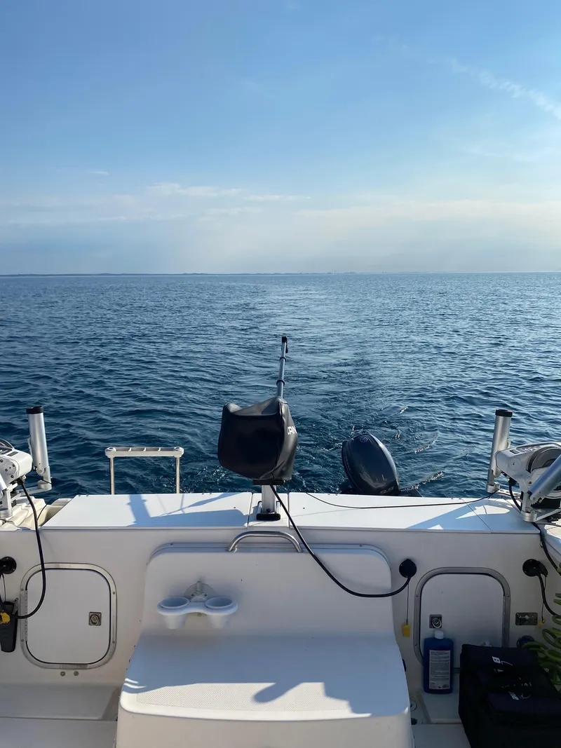 Slide: The Image of 1996 Trophy 2352 Walkaround boat on open sea under clear blue sky. - 2