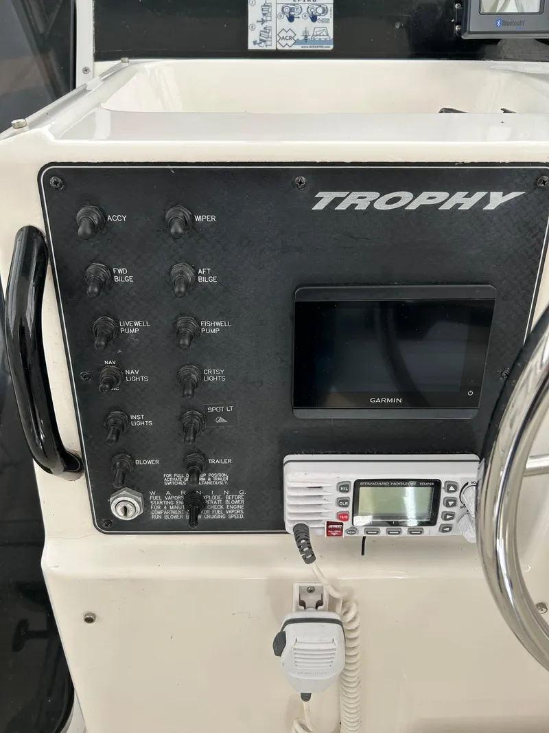 Slide: The Image of 1996 Trophy 2352 Walkaround boat dashboard with controls and Garmin display. - 20