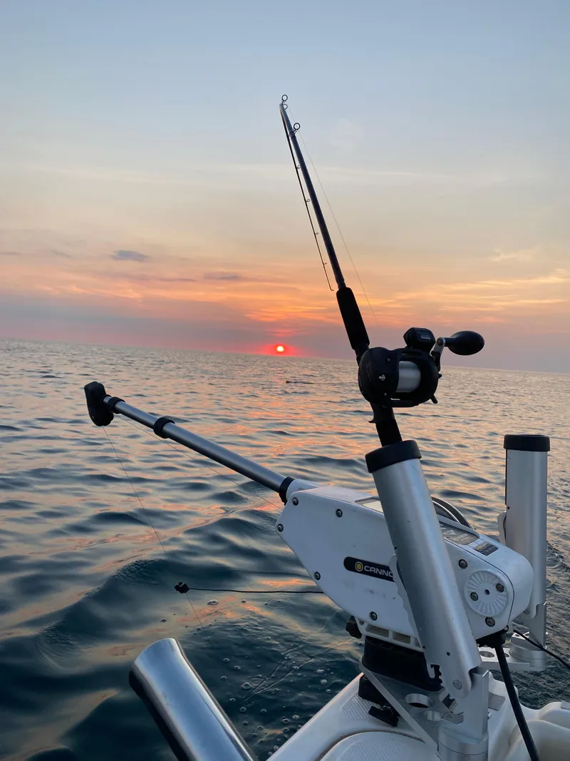 Slide: The Image of Fishing rod on 1996 Trophy 2352 Walkaround boat at sunset over calm ocean. - 6