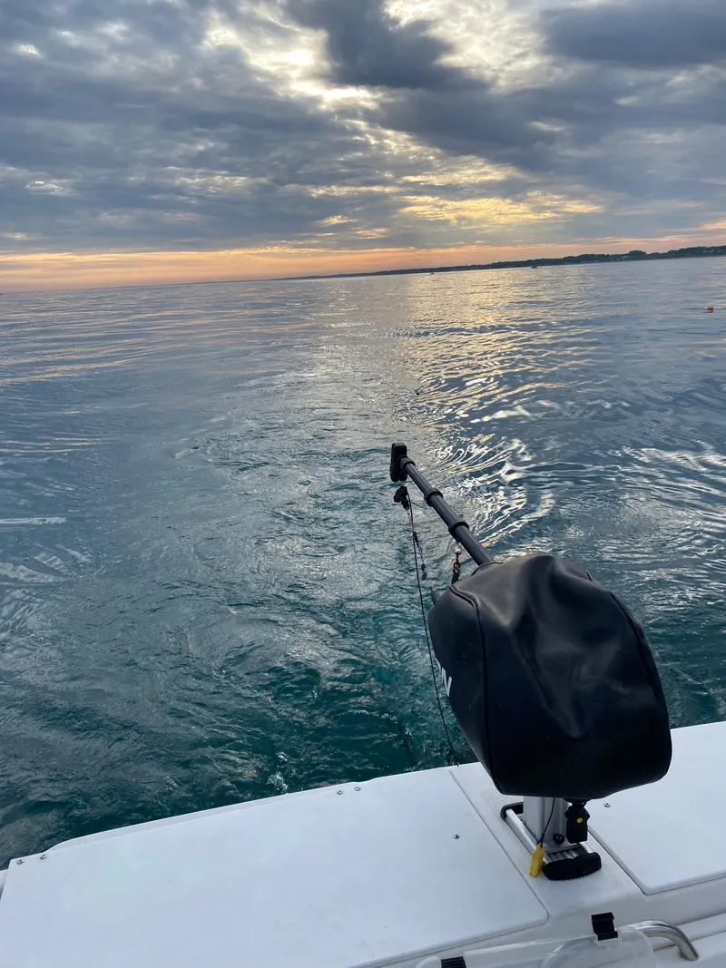 Slide: The Image of 1996 Trophy 2352 Walkaround boat on calm water at sunset. - 7