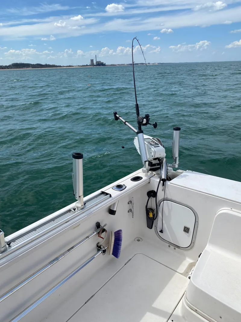 Slide: The Image of 1996 Trophy 2352 Walkaround boat on open water with fishing rod setup. - 9