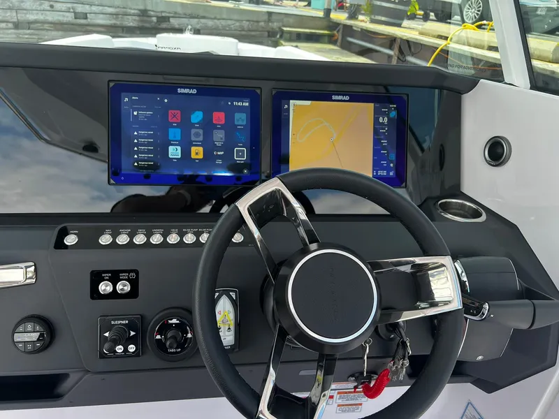 Slide: The Image of 2025 Axopar 29 CCX dashboard with dual Simrad displays and modern steering wheel. - 8
