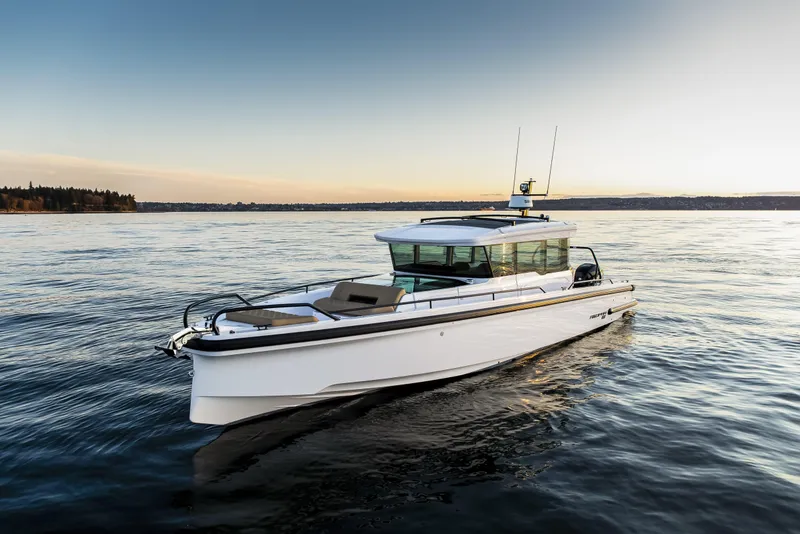 Slide: The Image of 2025 Axopar 37 XC CROSS CABIN boat cruising on calm waters at sunset. - 10