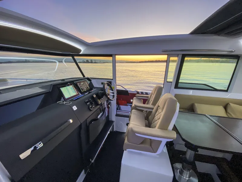 Slide: The Image of Interior of 2025 Axopar 37 XC CROSS CABIN at sunset, featuring modern helm and seating. - 20
