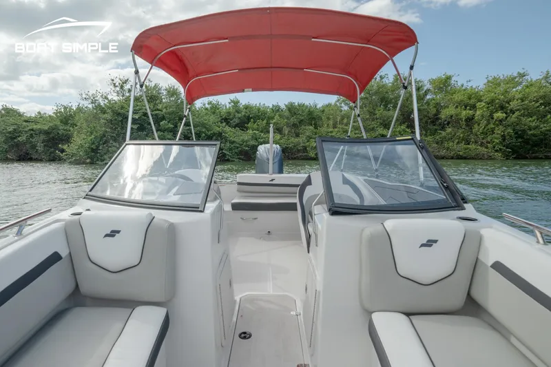 Slide: The Image of 2024 Starcraft SVX 210 OB DC boat with red canopy on a calm river. - 9