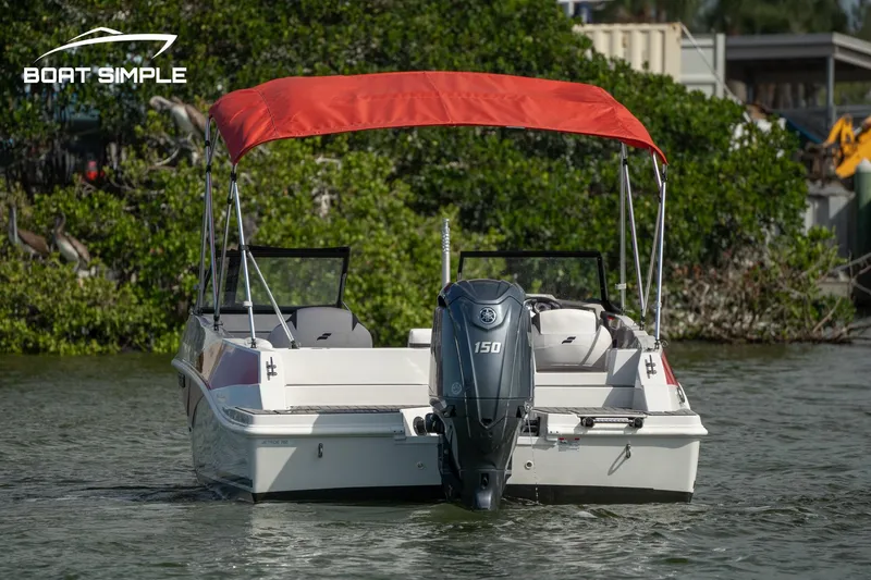 Slide: The Image of 2024 Starcraft SVX 210 OB DC boat with red canopy on water. - 4